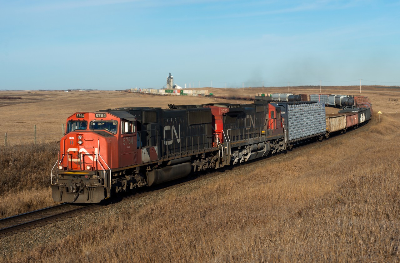 CN 114 rounds the bend at Oban Saskatchewan. Oban is the first station name west of Biggar on the Wainwright Subdivision. CP's Wilkie Sub is visible across the highway in the background.