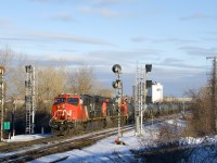 CN 377 is bathed in some nice winter light as it passes endangered searchlight signals at CN Dorval with CN 3052 & 2980 for power and 129 cars.