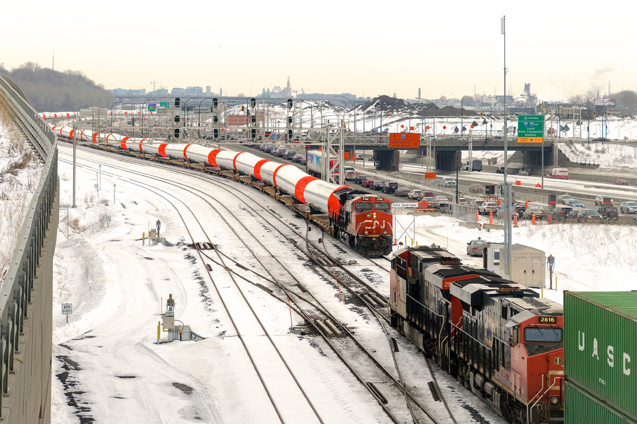 CN X148 is meeting windmill train CN X319, which is about to depart Turcot Ouest with a fresh crew. After setting off most of its train at Taschereau Yard, CN X148 is continuing towards the Port of Montreal with CN 2959 & CN 2816 for power. CN X319 has CN 3158 solo and 50 windmill towers.