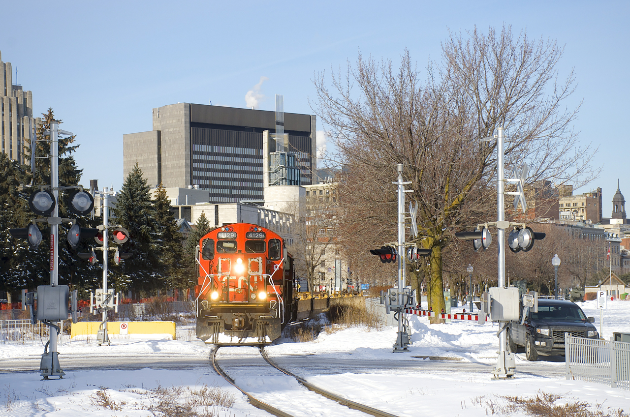 CN 4129 & CN 7032 are leading a baretable move out of the Port of Montreal as they approach one of the many crossings in this area.