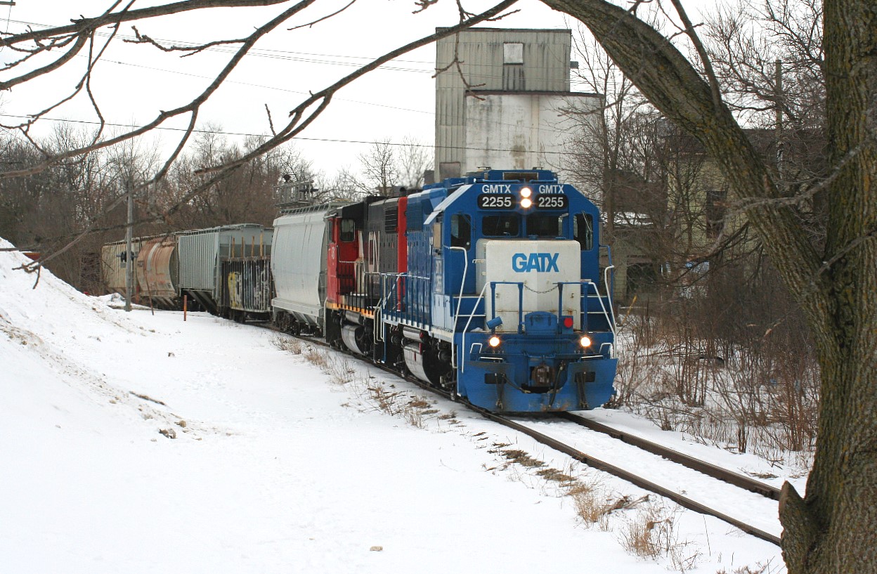 CN L568 with GMTX 2255 and CN 4761 are seen at Queen Street on the Huron Park Spur and are heading to the interchange with Canadian Pacific. The train also switched Ampacet Canada Corporation after setting-off their cars for CP.