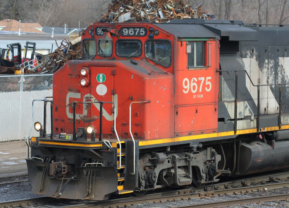 After seeing Steve's recent shot of CN 9675 at Guelph on the previous day's L540, I was reminded of a photograph I took of the same unit the following day as it switched the Kitchener yard during the morning. It was noted that the unit's former GO Transit heritage was coming through on the conductor's side, so here is a close-up of that, as the green paint of GO 708 can be seen above the window as well as on the bell.