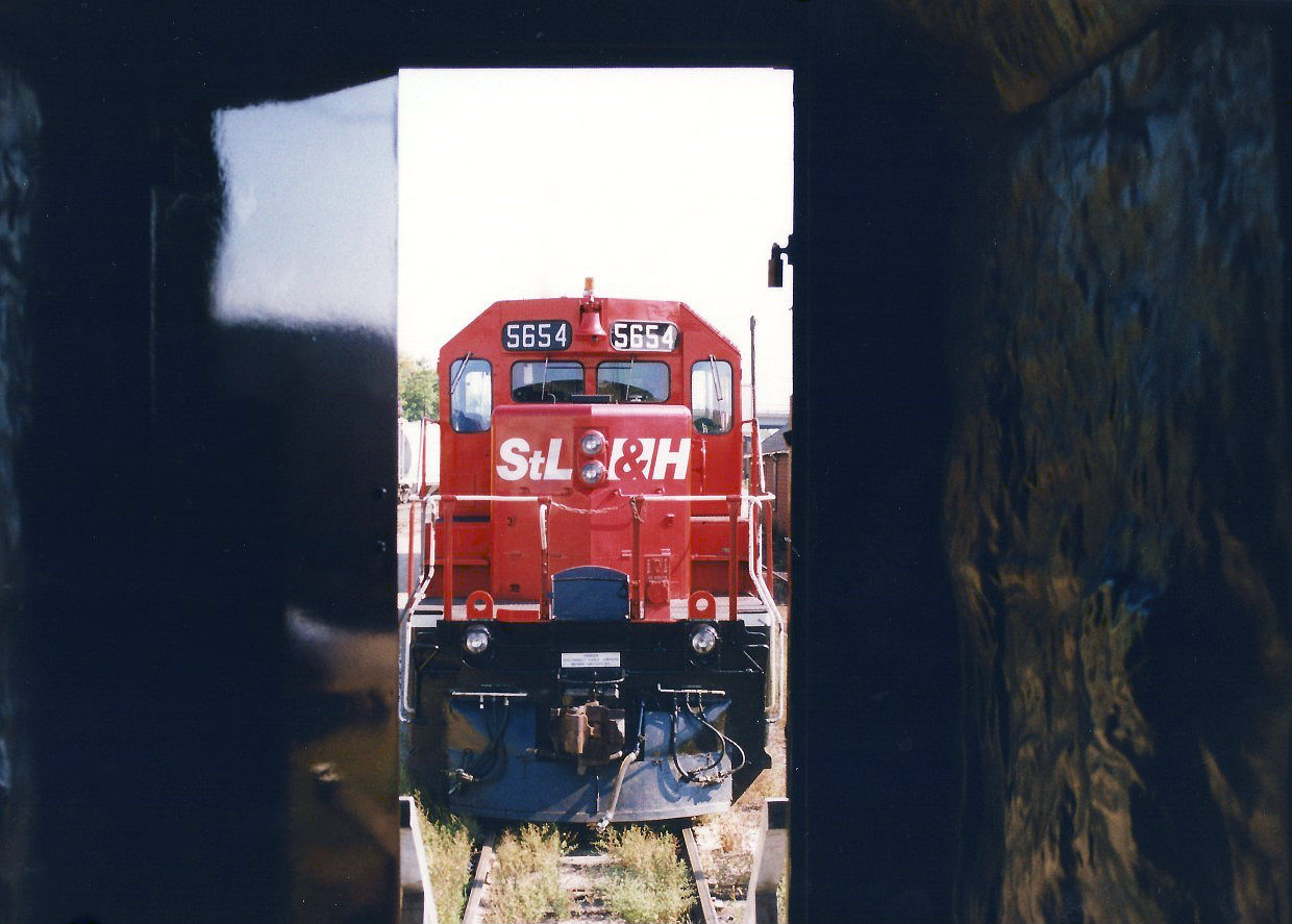During CP's Logo Train tour in 1997, attendees could tour the train and observe displays inside the cars that showcased the history of the newly revived beaver shield logo. While outside, freshly repainted CP GP38-2 3069 and STL&H 5654 were on display for photographers, gleaming in the morning sunlight at CP's Quebec Street yard in London. Here, STL&H 5654 stares back at those people walking through the cars taking in the history, while showing-off its own still semi-fresh paint scheme that was applied the year prior.