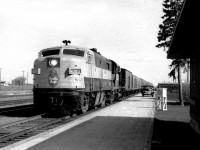 CP's westward Dominion, reduced to a primarily mail and Express train, led by an Alco FPa-2 a rarity in western Canada makes a stop at Virden. The ancient even by 1964 standards on the platform   belongs to the Post Office contractor. Express business was big, the Purolators, UPS, FedEx of the time when the railroads were the lifeblood on goods transportation.