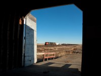 CN 301 is framed by the grain elevator door at Leney Saskatchewan.  The elevator like many others is no longer a Pool elevator, but rather is privately owned and used to store protect between harvest and trucking it to a larger inland terminal to be loaded on railcars.  