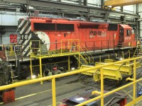 Sd40-2 6018 is in off a work train for some needed repairs. It's spotted on the track where GE engine overhauls are performed. That's a GE air compressor in front of it's rear truck and the engine lifting device on the adjacent track on a trolley.