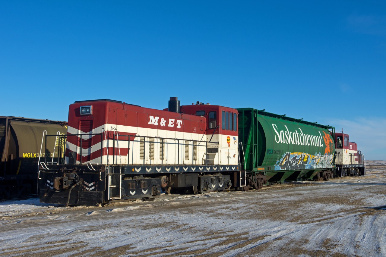 A pair of Mobil Grain's 70 tonners bracket a B/O grain car at the company's facility in Aylesbury Saskatchewan.