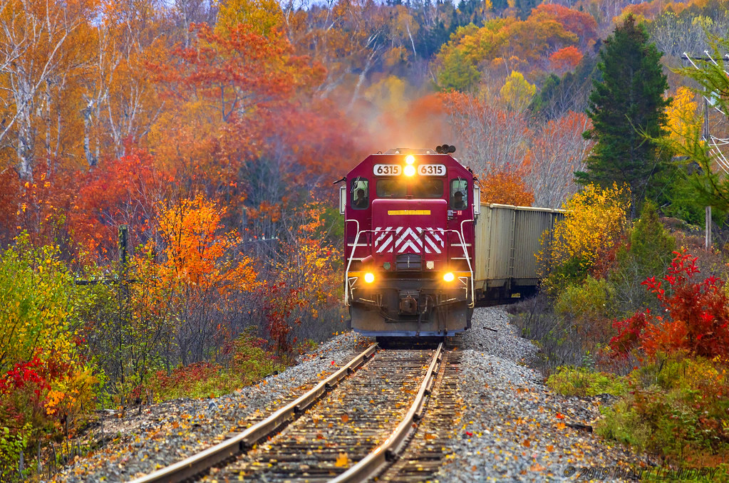 The last engine on NBSR's SD40 roster not to be repainted yet, NBSR 6315 leads westbound train 907, as they rumble through the Fall colors, approaching Nerepis, New Brunswick.