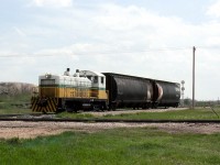 Bienfait Coal Co.'s ex MILW EMD TR4a 5706 with 2 cars of coal fines used in making charcoal BBQ briquettes crosses the the CN Lampman Subdivision on its way to the CPR Yard. The mine, formerly the Manitoba and Saskatchewan Coal co. shipped unit trains to Atikokan Ontario and Brandon Manitoba until steam generation was discontinued in early 2000's by both Manitoba and Ontario. Mine still serves the mine mouth Shand Power plant near Estevan but little moves by rail anymore from the once very busy Souris River coal fields around Estevan  