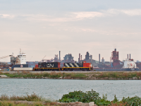 <b>Flat-switching among the freighters.</b> Throughout the summer of 2019, the GMD-1 siege into Hamilton was followed closely by many. With the help of a fellow Hamiltonian and keen observational skills, I was able to lock down the schedule of the 1600 yard crew. I quickly learned that Tuesday and Fridays were reserved for Eastport. Knowing this, I made it my mission to try and get CN North of Strathern while the days were still long. Not knowing their routine here, there was a lot of guess work that went into this. There are two places to run around cars at Eastport so I wasn’t sure if this angle would even be possible. I parked on the side of Eastport Drive (wide shoulders so not too dangerous…) on a hunch that ended up paying off. I’m glad this area is seemingly more accessible with the CN schedule. It’s one of the few seldom shot areas in Hamilton, which is a shame because it’s one of the most photogenic, <a href="http://www.railpictures.ca/?attachment_id=37163" target="_blank">as proven here by James Knott.</a> <p><p>
When I was doing this, a nice surprise came when I saw the background before me, courtesy of Algoma and Dofasco. In many ways I find it just as interesting as the GMD-1 subject matter. On the left side (or should I say “port side”…) is the 730’ self-unloader, the long John D. Leitch. Which is, I believe, the (or one of the) last forward cabin ship in Algoma’s fleet. Built in April 1967 in St. Catherine’s, a mere 33 kilometers from where I was standing when I took this shot. I’d shoot it without the trains to be honest. A complete contrast to this Canadian made classic is the <i>new kid on the dock</i>: the 740’ Algoma Equinox unloading at Dofasco on the right. This ship was built 2013 in China (11,386 km away for comparison) and was sailed half way around the world to begin hauling freight on the Great Lakes. This was the first of a many Equinox Class ships built for Algoma and making this the latest and greatest generation of ships operating in Algoma’s fleet. "   height=