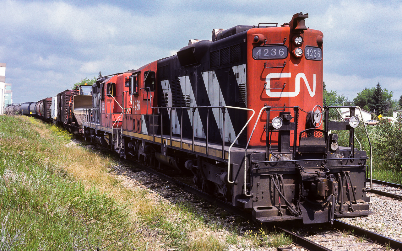 I did not put a date in my notes for this photo, the other photos on the roll will place the time safely as the middle of July. The 4236 has taken the siding at Gibbons, waiting for an eastbound. Besides the usual empty tanks from the airforce base and loads of grain, they have some work train cars on the headend. As I was taking my pictures, the hoghead and brakeman came out for a nice chat. If I was on the ball, I should have had them pose in front of their engine. In a short while they were on the way to Edmonton, the trailing unit is the 4330. Fortunately, both these units were rebuilt. The 4236 to the 7066 and the 4330 to the 7256. I could not find any recent photos of the 7066, maybe it is retired or sold. Michael Berry does have some recent photos of the 7256 in Montreal from 2016.