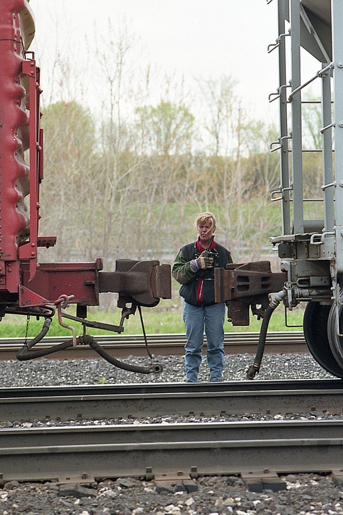 It is a physically demanding job but somebody has got to do it. In this case, it is one of the very few women I have seen on the railroad, taking charge.
Under her watchful eyes, CN #381 backs to a joint before heading westbound.
I am at Howard Rd in Aldershot.
This image is over 25 years old. Makes me wonder if the young lady toughed it out and made a career out of the railroad or not. If so, she is probably retired by now.