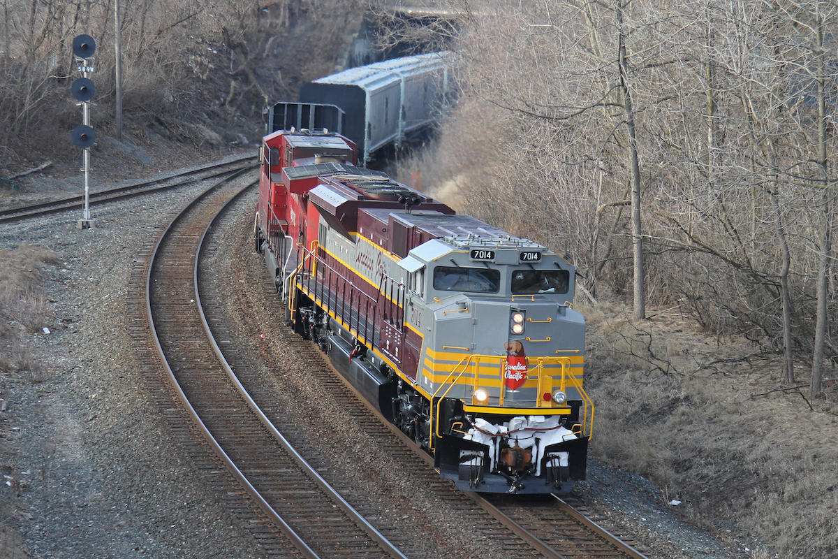 CP 7014 in Script Heritage paint passes the Main St. interlocking at MP 58.9 of the Hamilton Sub.  No sun at this location but was for the best as the trees cast shadows on the train as the sun appeared a couple of minutes after the picture was taken.  Picture taken from the Dundurn St. bridge.