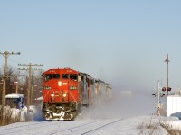 CN 373 with a pair of cowls (CN 2449 & CN 2445) kicks up the snow as it approaches CN Caron with 125 cars. It is the first freight train to use the Kingston Sub since at least the day before and will tie down at MP 147 of CN's Kingston Sub in Lansdowne, Ontario. This is due to a protest on CN's main line along Tyendinaga Mohawk territory, which has seen both freight and passenger trains unable to pass there since Thursday. 