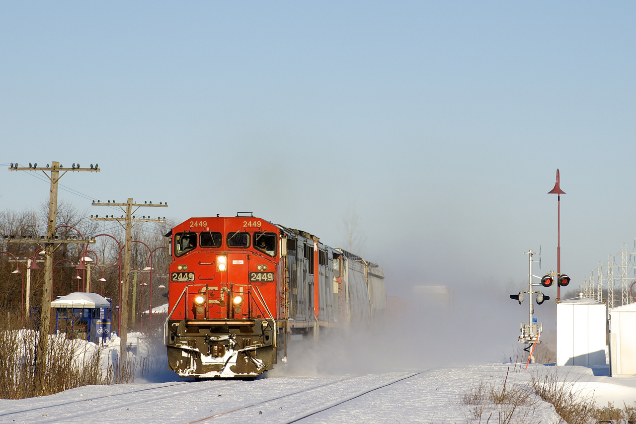 CN 373 with a pair of cowls (CN 2449 & CN 2445) kicks up the snow as it approaches CN Caron with 125 cars. It is the first freight train to use the Kingston Sub since at least the day before and will tie down at MP 147 of CN's Kingston Sub in Lansdowne, Ontario. This is due to a protest on CN's main line along Tyendinaga Mohawk territory, which has seen both freight and passenger trains unable to pass there since Thursday.