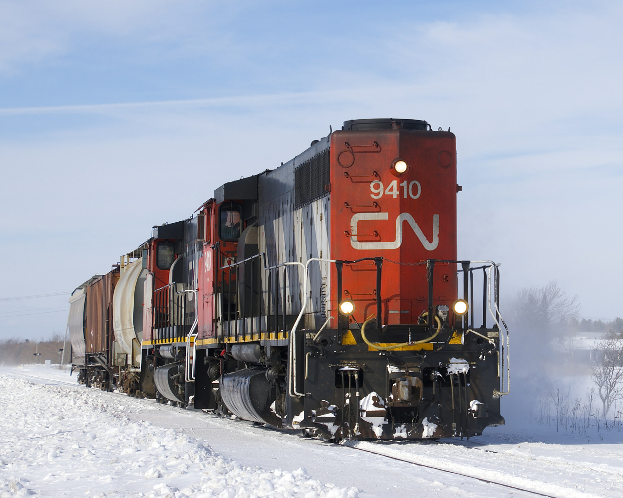 CN 522 with CN 9410, CN 9523 and 3 cars kicks up the snow on its way to switching a couple of clients in and near Saint-Jean-sur-Richelieu.
