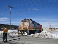 CN 522 has finished its work at Nova Grain and is about to head back to Southwark Yard as a crewmember flags the Rue Gaudette crossing. Power is CN 9523 and CN 9410.