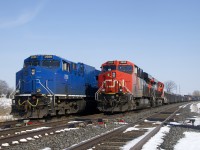 Two trains (M37721-06 & M32121-06) are parked near a crossing at MP 202.77 of CN's Kingston Sub, unable to continue west due to a protest on CN's main line along Tyendinaga Mohawk territory at the time. Apparently the line has reopened this evening. Of note is that GECX 2038 will soon be repainted into CN colours and receive a CN number.