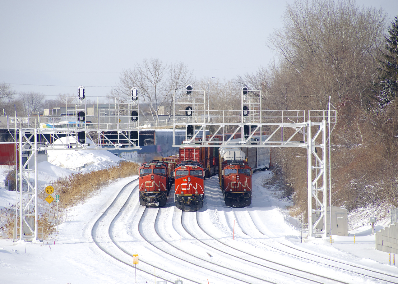 A trio of trains sit parked a bit west of Turcot Ouest; with the blockade of CN's Kingston Sub over, CN must have more traffic than crews can handle and trains were parked all over the place in Montreal this morning. From left to right are Q12031 28 (Brampton Intermodal Terminal to Rockingham, CN 2250 lead), Q12091 27 (Chicago to Rockingham, CN 3895 lead) and E27661 28 (Flint to Joffre, CN 5707 lead).
