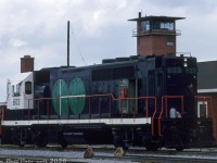One of those rare-to-find angles: GO Transit GP40TC 603 shows off the as-built rear end of its long hood a day before the official launch of GO Transit service on May 23rd 1967, sitting at GO's Willowbrook Yard by the former CN Mimico Yard freight car repair shops that GO used in its early days. Note the old CN yard tower in the background. The old facilities GO took over were located at the <a href=http://jpeg2000.eloquent-systems.com/toronto.html?image=ser12/s0012_fl1966_it0023.jp2><b>northeast part of CN's Mimico Yard</b></a>, off Judson Street (by Willowbrook Road) and east of present-day Islington Avenue (also see Bill Thomson's photo <a href=http://www.railpictures.ca/?attachment_id=32164><b>here</b></a>). <br><br> Eight GP40TC (Toronto Commuter) units were built by GMD London in late 1966 for the Government's of Ontario's new experimental passenger commuter service, basically a GP40 on a longer SD40 frame that allowed a separate HEP generator to be included at the rear. They initially emerged sporting the numbers 600-607 and were delivered in a solid coat of very very dark blue (but with black underframes) and CN noodles on the cab sides. They were used for a few months in CN freight service before GO's startup, and later had their cabs and frames painted white and GO logos applied in preparation for GO's "Day One". The unique units, later numbered 9800-07 and finally 500-507, served GO for two decades until they were retired and sold to Amtrak in 1988, after the first order of new F59PH units rendered them surplus. A few rebuilds and paint jobs later, and they're still in service on Amtrak as de-turbo'ed "GP38H-3" units. <br><br> <i>John F. Bromley photo, Dan Dell'Unto collection.</i> <br><br> <i>(A note to the modellers out there, the rear ends were modified a few times over their service lives on GO, notably the HEP hood section and rear end/anticlimber setup, so always consult era-specific prototype photos when possible. I also checked data sheet diagrams, and verified that the GP40TC frame shows the same end-to-end measurements as a standard SD40 frame).</i>