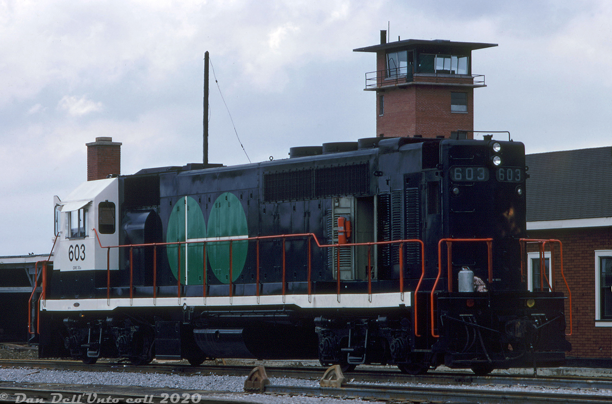 One of those rare-to-find angles: GO Transit GP40TC 603 shows off the as-built rear end of its long hood a day before the official launch of GO Transit service on May 23rd 1967, sitting at GO's Willowbrook Yard by the former CN Mimico Yard freight car repair shops that GO used in its early days. Note the old CN yard tower in the background. The old facilities GO took over were located at the northeast part of CN's Mimico Yard, off Judson Street (by Willowbrook Road) and east of present-day Islington Avenue (also see Bill Thomson's photo here).  Eight GP40TC (Toronto Commuter) units were built by GMD London in late 1966 for the Government's of Ontario's new experimental passenger commuter service, basically a GP40 on a longer SD40 frame that allowed a separate HEP generator to be included at the rear. They initially emerged sporting the numbers 600-607 and were delivered in a solid coat of very very dark blue (but with black underframes) and CN noodles on the cab sides. They were used for a few months in CN freight service before GO's startup, and later had their cabs painted white and GO logos applied in preparation for GO's "Day One". The unique units, later numbered 9800-07 and finally 500-507, served GO for two decades until they were retired and sold to Amtrak in 1988, after the first order of new F59PH units rendered them surplus. A few rebuilds and paint jobs later, and they're still in service on Amtrak as de-turbo'ed "GP38H-3" units.  John F. Bromley photo, Dan Dell'Unto collection.  (A note to the modellers out there, the rear ends were modified a few times over their service lives on GO, notably the HEP hood section and rear end/anticlimber setup, so always consult era-specific prototype photos when possible. I also checked data sheet diagrams, and verified that the GP40TC frame shows the same end-to-end measurements as a standard SD40 frame).