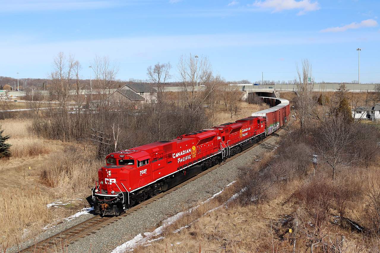 Two beautiful freshly painted red barns glide down the Hamilton sub and appear from under the Highway 403 bridge as they head south approaching the Newman Road overpass on there way south for a stop at Kinnear.
CP 7027 and CP 7008 provide the power.