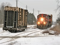 For years and years the one thing that you could always count on when you drove along Edinburgh Road in Guelph was seeing one or more pole cars sitting in the small siding off the Guelph North Spur. These pole cars were unloaded onto a truck right there beside the street, by Guelph Utility Pole, which is actually owned and the cars are billed out as Stella-Jones. Stella-Jones is a large producer of industrial pressure-treated wood products and leases many railway cars for this type of service. 

While I always would see these cars along Edinburgh Road either loaded or empty, photographing a train setting them off or being lifted proved difficult as the lighting was usually never favorable due to the location, as you are either shooting more or less into the sun or its backlit. I had only ever shot the Goderich-Exeter Railway setting-off here in 2008 and as mentioned the lighting was not great. 

Flash forward almost 11 years and now CN was once again operating the Guelph North Spur. On a Sunday afternoon I heard some chatter on the scanner and soon discovered that L540 was finishing-up some switching in the yard with 4130 and 4761. The train soon departed and slowly trundled-up the North Guelph Spur with one single boxcar for a customer.  Being an overcast afternoon actually worked-out for the better as I was able to photograph L540 passing a loaded pole car in the siding along Edinburgh Road. It wasn’t long after this photo was taken that I read that Guelph Utility Pole had switched over from CN to the Guelph Junction Railway. This traffic is now handled by Ontario Southland out of Guelph Junction and is reportedly unloaded on a team track still in the city. 

As always, any additional information or corrections to the caption would be appreciated. 
