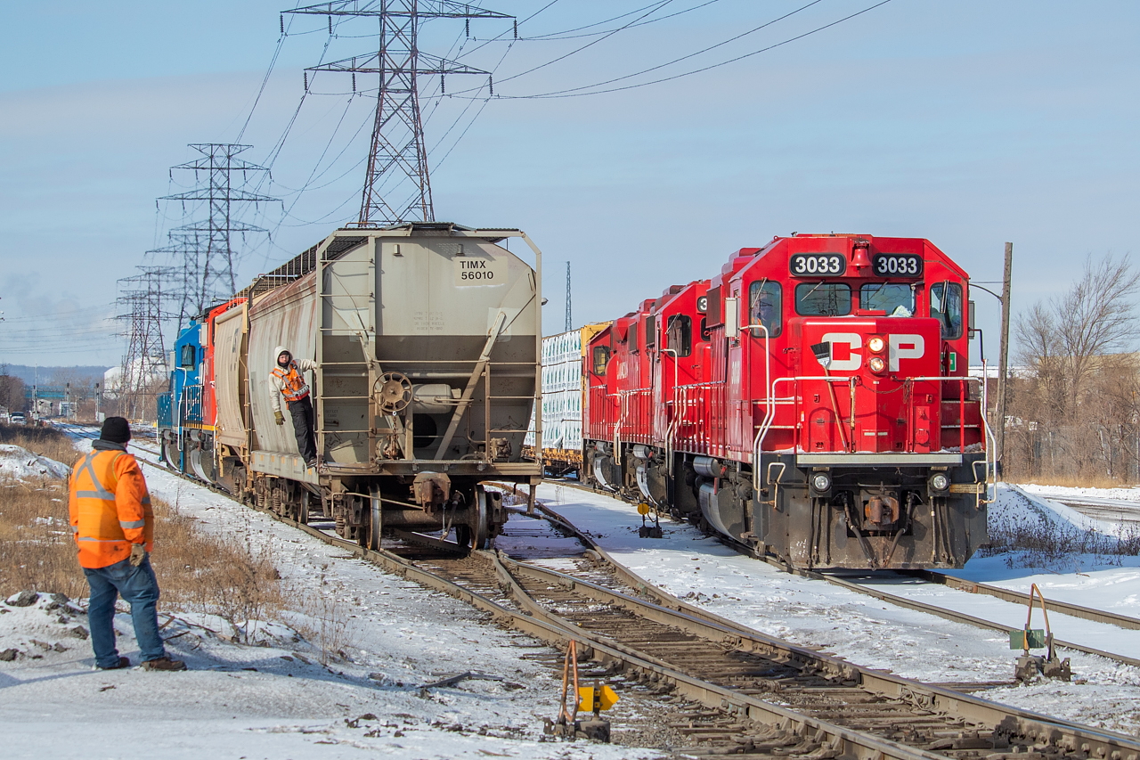 CP and CN were following each other all over town on this particular Saturday. Just prior to this shot, CN had just gone up to Railcare and Bell & MacKenzie. They dropped one car at Railcare and lifted another (the TIMX hopper pictured - one that is often seen at Bunge in Hamilton), and lifted one empty from Bell & MacKenzie (the two-bay CSX pictured). While CN was at Bell & MacKenzie, CP dropped one boxcar at Railcare. Next, it was over to the Ottawa Street North area for both, pictured here. CP was there to drop four cars at the interchange for CN - three loaded centrebeams (likely for Turkstra Lumber on the Grimsby) and one tank. CN meanwhile was shoving past on the N&NW Spur, heading eastward. The crew member standing in the foreground was on CP TH31, but he was nice enough to line the switch for the crew of the CN 0600 Yard Job. Once CN shoved past, CP pulled east across Ottawa Street North to clear a switch, and shoved back to set the cars off for CN. Next stop for both was National Steel Car, where they each pulled a pretty big string of cars out - both doubling their trains there. Among CP's pull was new cars for American Iron & Metal, which they later dropped off at AIM's Hamilton facility that very afternoon - about 1.5km away (as the crow flies) from where they were manufactured by NSC.  The full set of power for CP on this day was 3033, 3042 and 3040. The CN 0600 was CN 9416 and GMTX 2289. I had previously shared a shot of a meet at this location between SOR and CP, available here. Like CN in this shot, SOR was also shoving eastward at that time as well.