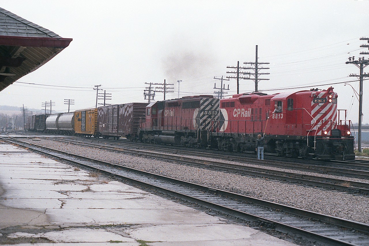 A CP eastbound stops for orders hooked up at Woodstock on a miserable rainy morning. Power is CP 8813 and 5553. I don't recall seeing all that many of these GP9s around by 1985; most were going off for rebuilds.