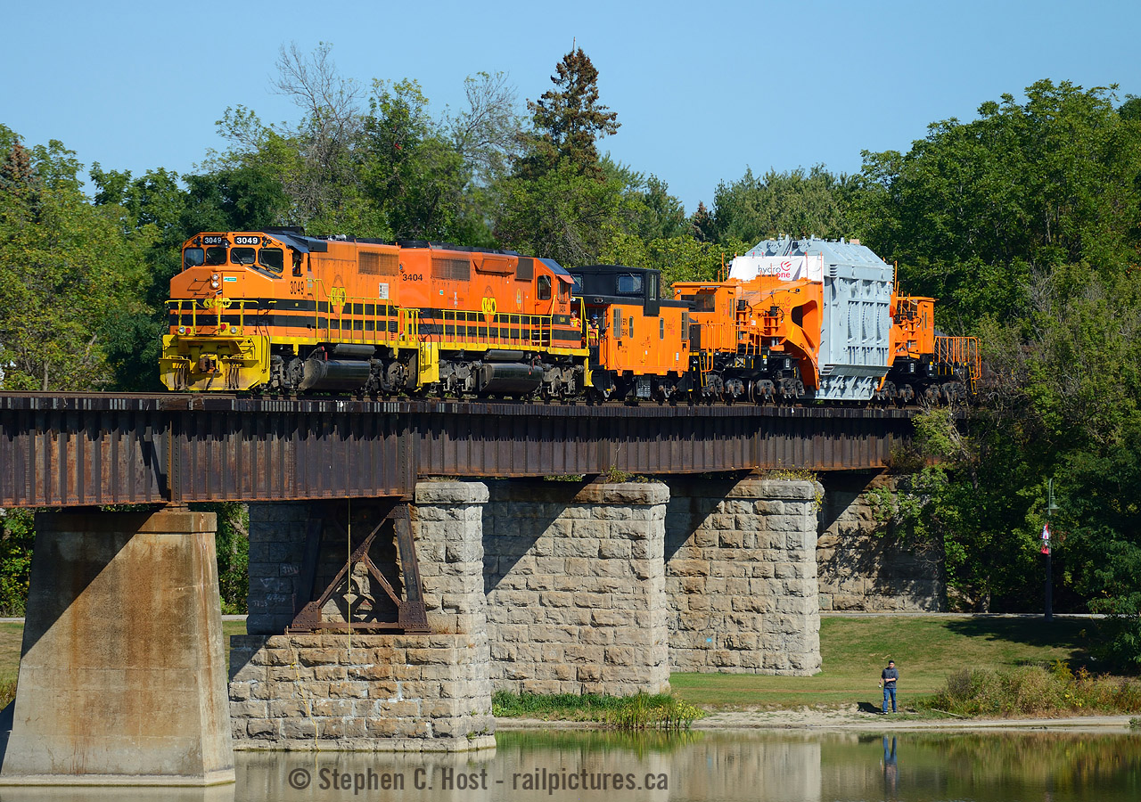 A train that could easily be mistaken as made for each other, or found on someone's model train set. The GWRR orange with the famous HEPX 200 Schabel and river caboose just look as they are owned by the same company, seen crossing the Grand River at Caledonia. Not the person bottom right for scale.