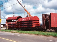 Brand new covers for CN gondolas are being cautiously unloaded from bulkhead cars at CN’s Stuart Street Yard in Hamilton. Once unloaded the covers were placed on cuts of awaiting gondolas that were set-off in the yard.