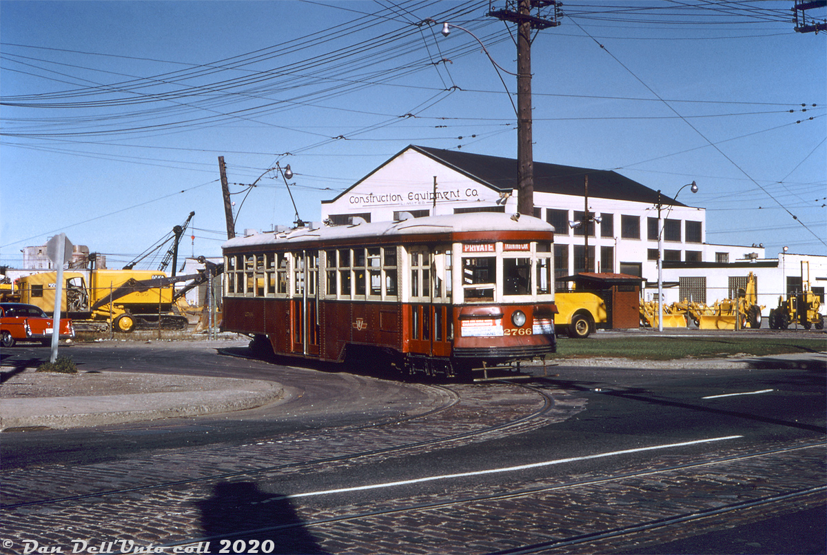 TTC Peter Witt streetcar 2766, operating on a Sunday fantrip, is seen posing at Townsley Loop off Old Weston Road north of St. Clair Avenue on the morning of September 6th 1964. By this time, the TTC's University subway line opening earlier the previous year had nixed the old Dupont streetcar line and reduced demands of the streetcar fleet, notably affecting the remaining old Peter Witt cars. They were kept around as spares, but saw infrequent service and retired the following year in 1965. In the meantime, they were popular for fantrip charters, a number of which were run in 1963-65 with some of the remaining units, including cars 2742, 2766, 2858, 2868, and 2884. Even after its July 1965 retirement, TTC kept car 2766, which would later return in the 70's for Tour Tram service and is still retained by the TTC today.

Townsley Loop was located on a small parcel of land at the north-west quadrant of Old Weston Road and its namesake Townsley Street, by this point mainly serving as a spot to short-turn St. Clair streetcars (it remains today, but with tracks removed and serving as a bus loop). In the background is Construction Equipment Company Ltd, a local construction equipment and tool sales, service, and rentals dealer located at 404 Old Weston Road. According to old promotional materials, they had branches in Toronto, Montreal and Halifax, and dealt with small-to-medium sized equipment like backhoes, bulldozers, cable shovels, cranes, mixers, compressors, etc for local construction, road work and such. They had a rail spur off CP's MacTier Sub at one point (although a 1966 timetable lists them as "Godson's"). It appears the property was redeveloped around 1976 into the current commercial retail building there today, presently home to a flea market.

John F. Bromley photo (duplicate slide), Dan Dell'Unto collection.
