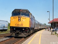 VIA train #45 pulls into Cobourg station on a sunny afternoon, with F40PH-2 6432 in the lead followed by a string of stainless steel Budd passenger cars.