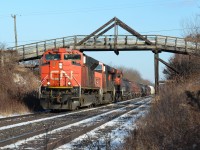 Definitely not the coolest thing on CN’s roster up in lead, CN 331 (when it existed) drags it’s 150 car train down hill towards Komoka Junction passing under the scenic bridge at Franks Lane west of London that goes over the CN here, and under the CP to the north (left). The Kingpost truss bridge apparently was a rare form of truss bridge that had metal supports on the vertical parts on both sides as the rest of the bridge was made from solid wood. It definitely makes for a better picture location shooting the train going under this cool piece of infrastructure then standing on it shooting the plain straight double track and farm fields. 