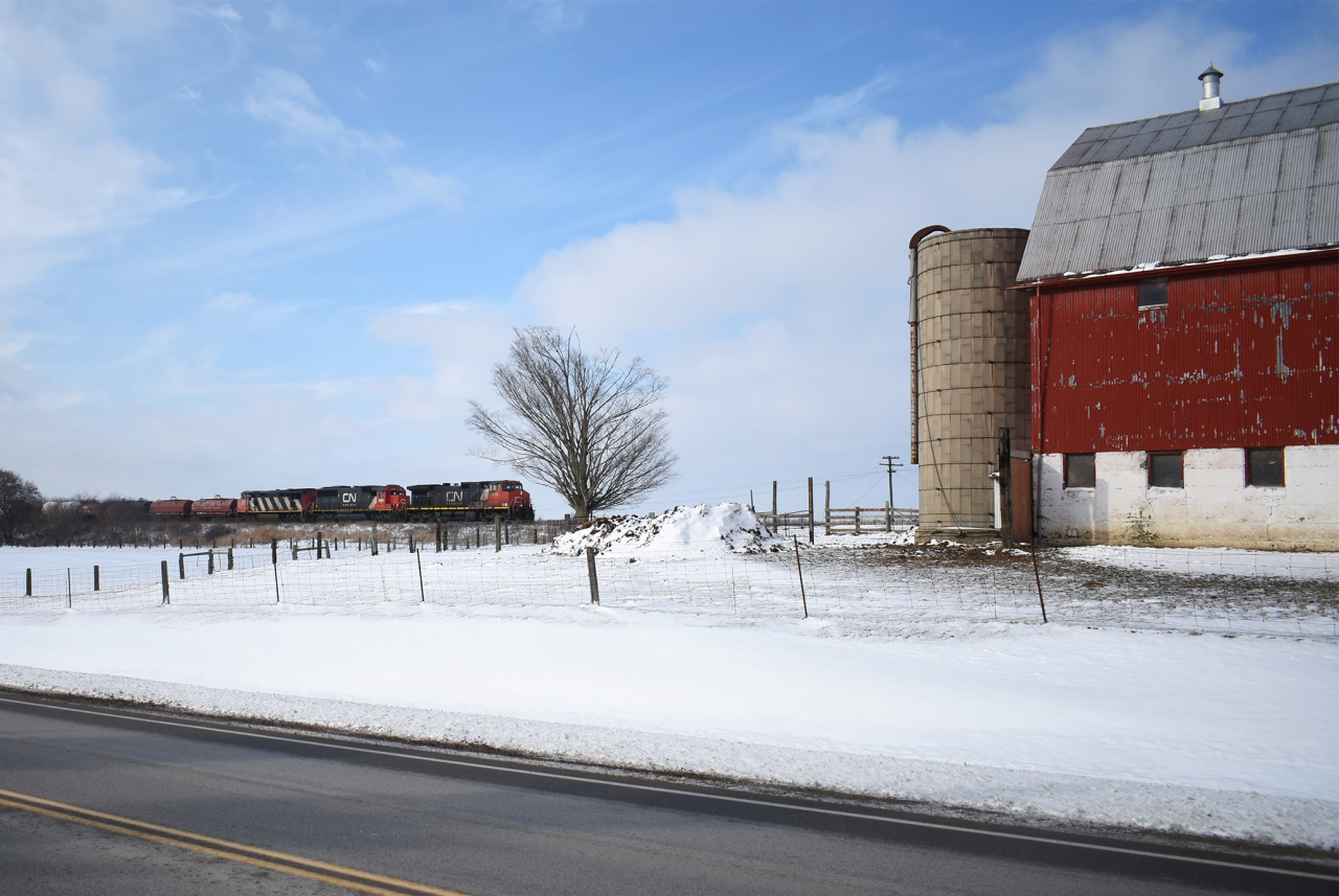 CN L509 rolls through the snow covered hills of Southern Ontario Eastbound for London. With the barn of a family farm alongside the tracks this spot has been a favorite among photographers along the Strathroy sub for over 50 years now.