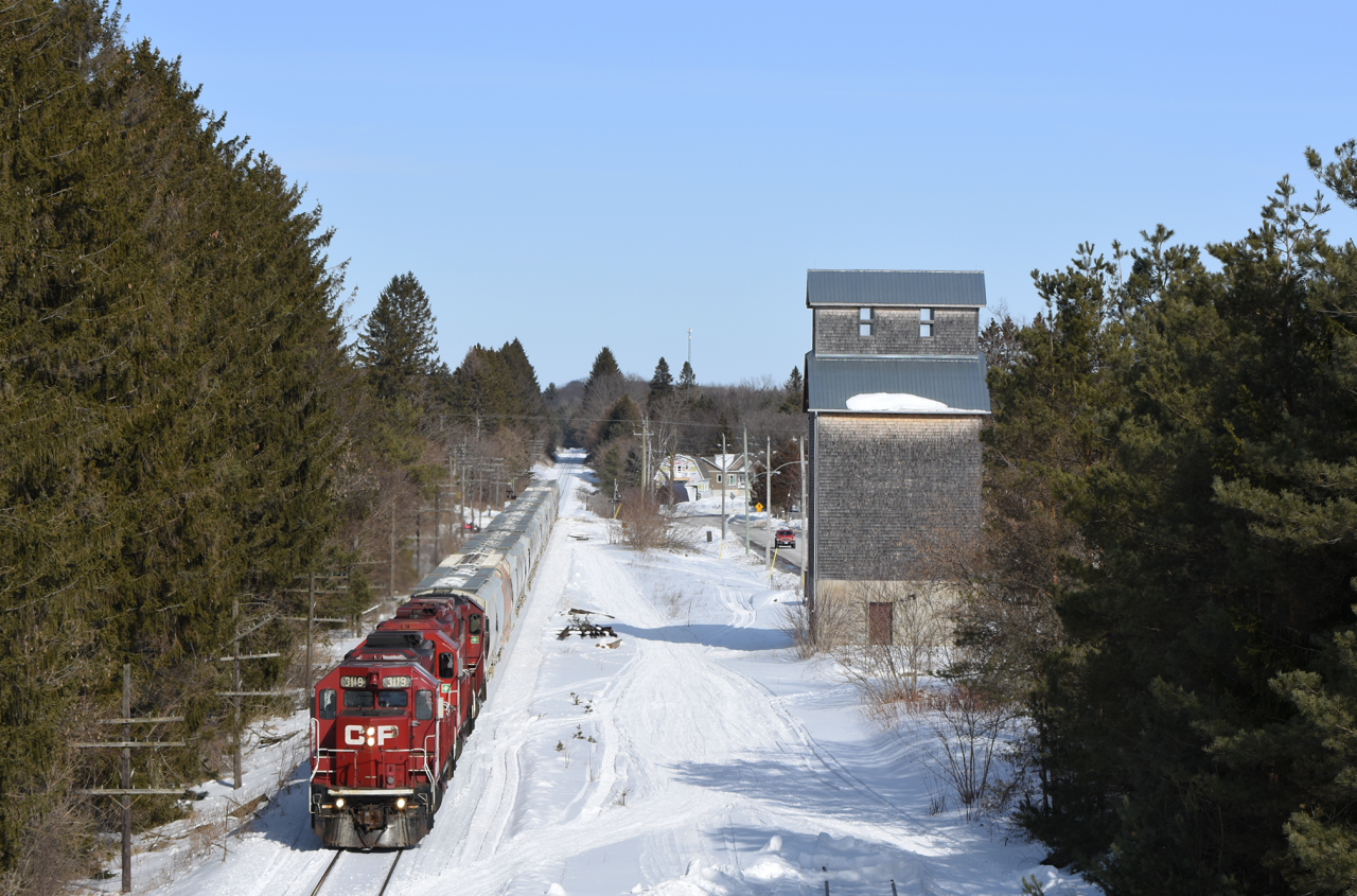 With about 20 2 bay hoopers in tow from the Nephton mine, CP 3119 and 2 other GP38 counterparts slowly roll past the 102 year old Pontypool Elevator. Built in 1918, this elevator is one of two free standing elevators still in Ontario and the last of it's kind. It's counterpart being the slightly older elevator in Port Perry.
