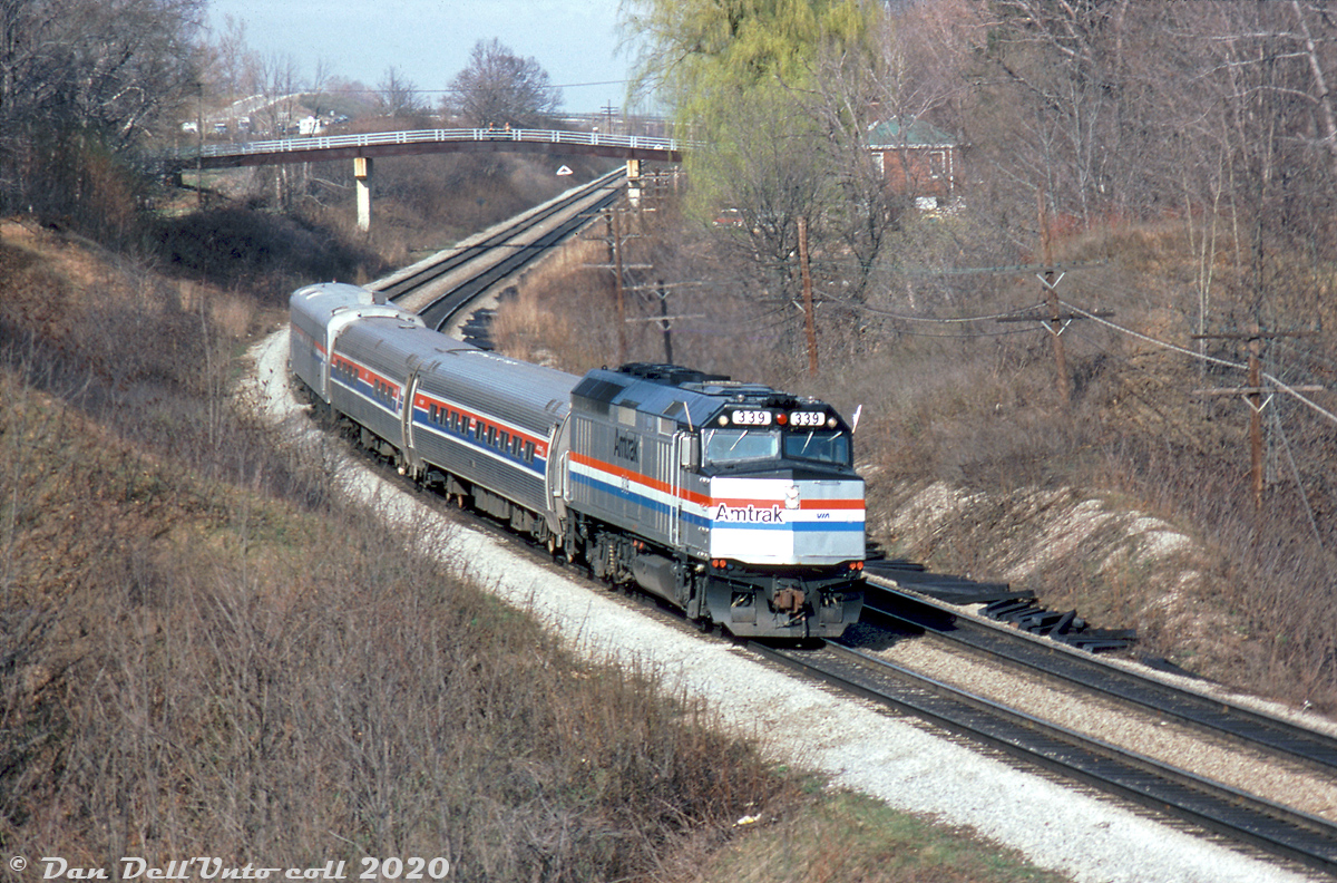 The first run of VIA-Amtrak's joint "Maple Leaf" was on April 27th 1981, but it appears some test runs were done before then. Earlier that month, Amtrak F40PH 339 (bearing extra flags), heads westbound through Bayview on the Oakville Sub with a short Maple Leaf test train consist of two Amfleet cars and what appears to be a business or private car on the tail end. Amtrak 339 was the only unit to bear a small VIA logo on the nose, which only lasted about a year (by mid-1982 it was buffed off). Power-wise, Amtrak F40PH units were staples on the Maple Leaf train for years, including after the former GO Transit GP40TC's began showing up in the late 80's. 

Bill McArthur photo, Dan Dell'Unto collection slide.