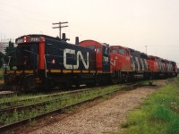 CN 421 is viewed waiting at the Kitchener yard for the 15:30 Kitchener Job to return from the Huron Park Spur with their lift of newly built frames from the Budd Plant. 421's consist included; 9560, 9620, 9490 and 7311. August 16, 1993.