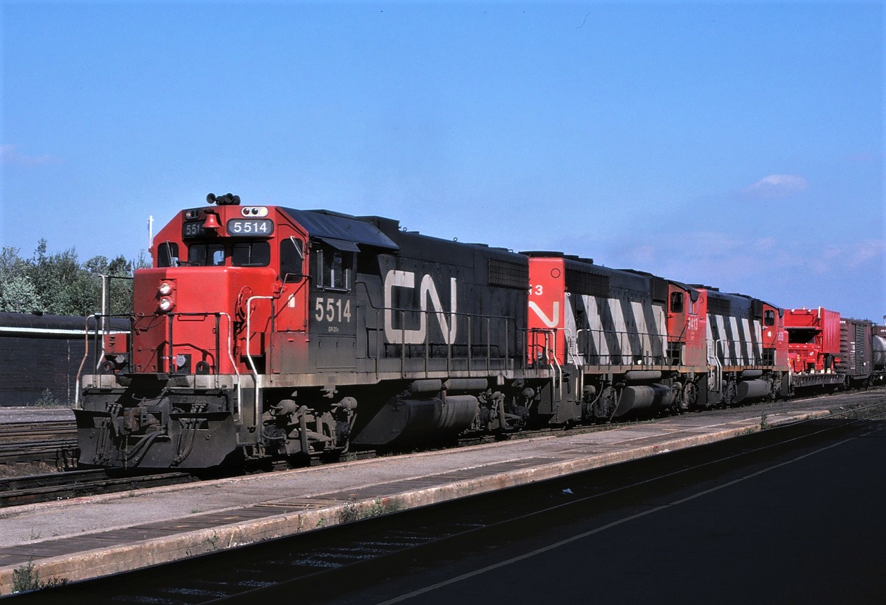CN freight train #301 pulls past the Capreol, Ontario station on September 2, 1979.  Power for the train is 8,000 HP in the form of GP38-2 5514 (wearing only one white flag, but both white class lights on) and GP40-2L(W)s 9413 and 9606.  Interesting load first up!!