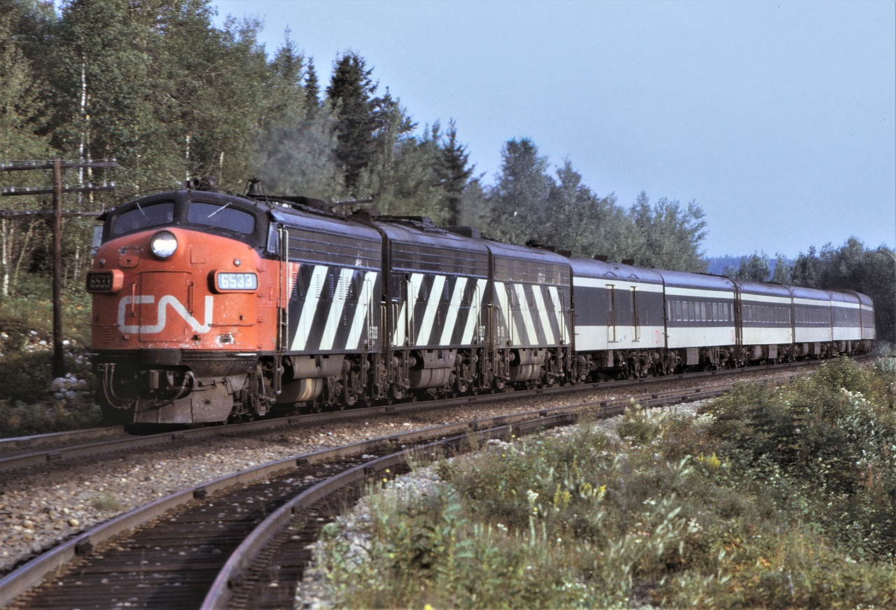 The Toronto section of CN's Super Continental, train # 4, drifts through Laforest, Ontario on August 21st 1972.  Power for the train is a classic A-B-B set of General Motors passenger units.