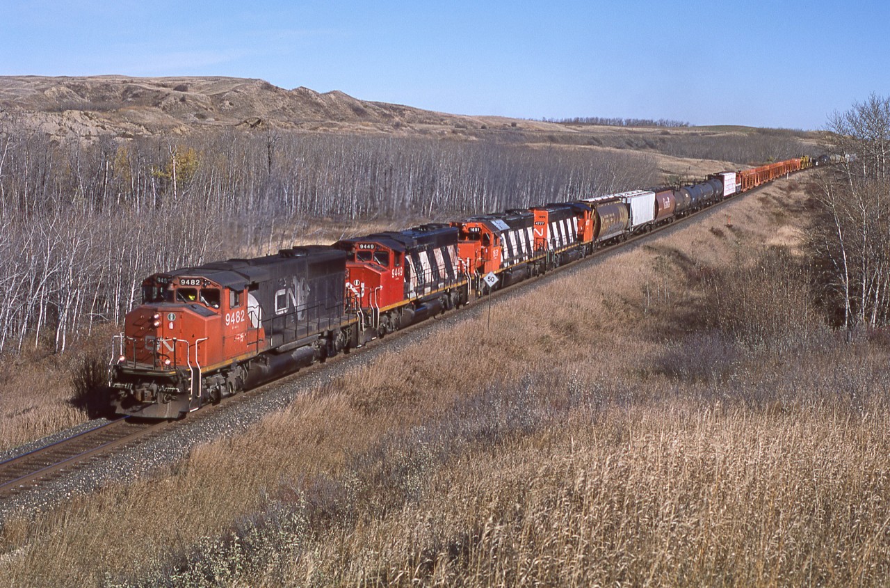 CN 9482,9449,1651, and 4777 lead a mixed train of local cars for Biggar and "old dates" out of Saskatoon yard. This scene changed significantly in late 2019 when CN double tracked this stretch of the Watrous Sub. A keen eye will also note a BCOL caboose 9 cars back.