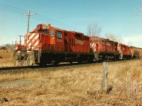 On Good Friday in April 1996, my notes indicate that the Galt Subdivision was busy that afternoon. The conductor of the Hamilton Turn is viewed walking back to his train after activating the switch to enter the east siding switch at Wolverton, just west of Ayr. Here, GP9u 8212, C424 4242 and GP9u 8237 will meet eastbound train 510 before continuing westward to London. 

