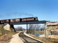 Canadian Pacific RS10 8587 leads a string of 40' boxcars southbound on the MacTier Subdivision, crossing over CN's Beeton Subdivision just south of Beeton in May of 1966. Today the MacTier Sub remains as CP's mainline out of Toronto to the west. CN's Beeton Sub has been mostly abandoned, but this part of the line remains as a small segment that became part of the South Simcoe Railway's tourist operation between Tottenham and Beeton.