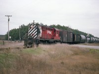 I just got to thinking to post this for those of you who knew the old CP St. Marys Sub between Ingersoll and St. Marys when it was a going concern. The southern section from Zorra to Ingersoll as I remember it was taken up in the summer of 1987, and the 24 or so miles from Zorra northward to the end at St. Marys was pulled around 1999, save for a piece to serve industry off the Galt Sub at Zorra.
This image is of CP 8777 crossing County Rd 16 just northwest of Embro on its' way to St. Marys. Not sure, but think 8777 was based out of Woodstock back then.