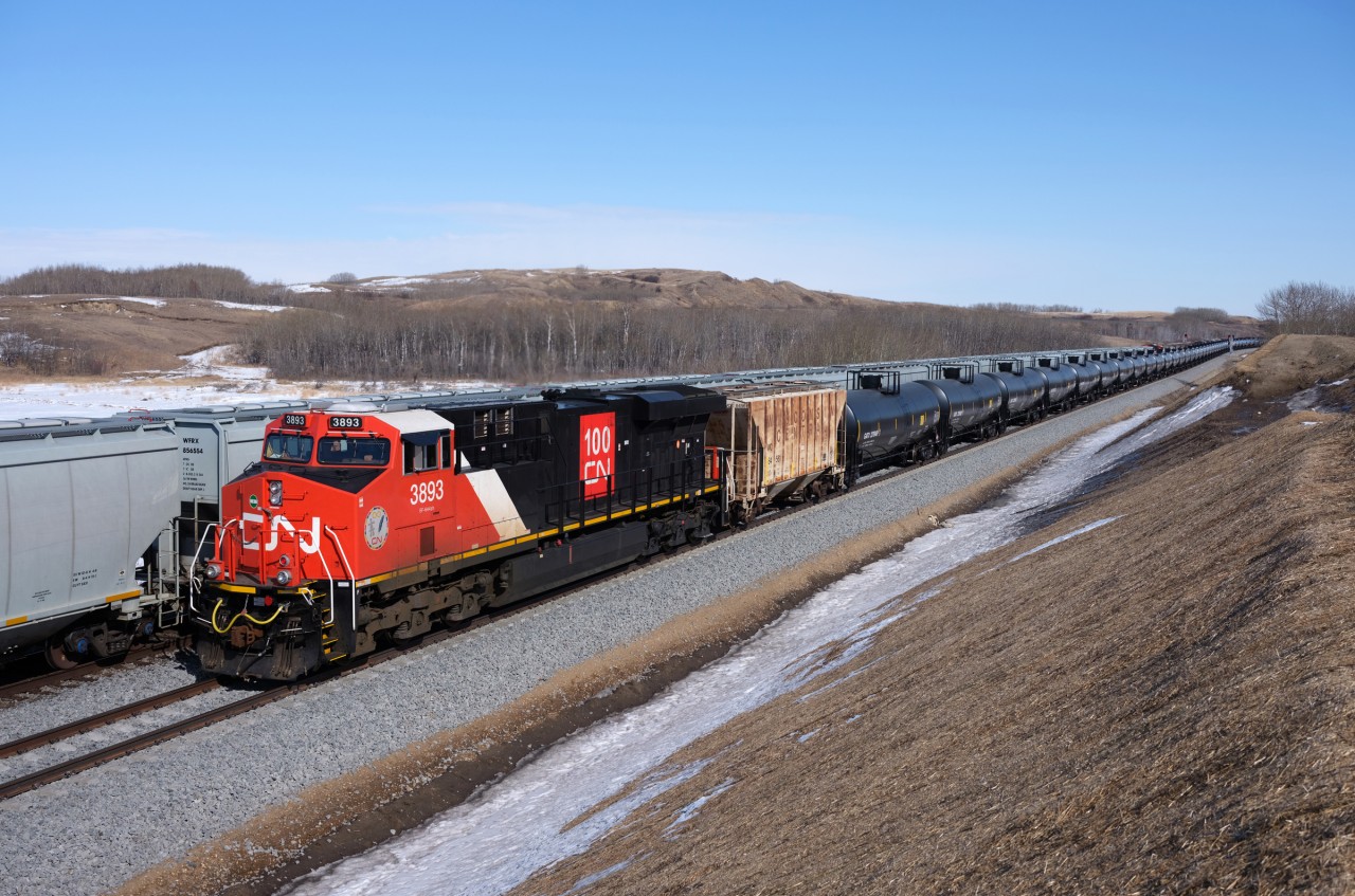 In a what can easily be described as a very "clean scene" CN 3893 brings up the rear of a loaded crude oil train while meeting a loaded GrainsConnect westbound on the recently completed stretch of double-track between Biggar and Newton.