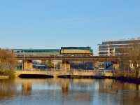 VIA 87 slows to it's stop at Guelph crossing the 1856 Grand Trunk 'Allan's Bridge.'  So-named for Allan's mill and distillery which stood below next to the Guelph Junction Railway (eventual CPR Goderich Sub).  Looking beneath the main span where the locomotive is, one can see the current Spring Mill Distillery.  The mill and distillery (ruins of mill behind limestone pillar to right of distillery - Speed river running between them) were built in 1830 as wood structures by Horace Perry for the Canada Company.  The Canada Company had been founded through an Act of Parliament in 1825 to settle the area of the Huron Tract, stretching from the shore of Lake Huron throughout Southern Ontario.  The Canada Company was founded by John Galt; founder of Guelph (1827), and co-founder of Goderich (1827) with colleague William "Tiger" Dunlop (town plans for the two were apparently swapped for each other mistakenly during construction).  The nearby settlement of Shade's Mills would eventually be renamed Galt, Ontario after John Galt; eventually his name also being used for the CPR Galt Subdivision.<br><br>From it's 1830 roots for the Canada Company, the grist and flour mill, distillery would be sold to William Allan, and his son, David during the 1840's, leading to the wood structures being removed and replaced with the current limestone structures circa 1850.  The operations continued until a fire in 1883 that gutted the interior.  The business folded and the buildings were used for other ventures in subsequent years.  In 1909 the mill building would be used by the Flexible Conduit Company, expanding by 1918 to make light bulbs and changing to the Dalyte Electric Company.  the business would close in 1929 as the Great Depression hit.  The mill building ended it's life as Doughty & McFarlane; a feed and seed business.  The business was entirely destroyed by fire on January 2, 1966, including the neighbouring brick structure erected by Daylite Electric (circa 1918 - also part of Doughty & McFarlane).  The mill building partially remained in derelict condition until demolition throughout 1975 and 1976.  The site is now known as Heritage Park (created 1977 as Allan's Mill Park), and contains stone ruins of the mill, a flywheel, and other industrial implements.  Located on a trail by the river, it provides nice vantage points for the OSR, such as <a href=http://www.railpictures.ca/?attachment_id=13602>Steve's shot</a> which includes the distillery building.  After the 1883 fire, the distillery building area of the "Mill Lands" were purchased by Thomas McCrae and later David McCrae of the Armstrong & McCrae woolen Company.  These two would be the Grandfather and Father to john McCrae; WWI Doctor and poet of 'In Flanders' Fields'.  They expanded the site with a stone factory adjoining the old distillery property.  The site would be taken over by the A.R. Woodyatt Company (1899) and, after merging with Guelph Malleable Iron Company in 1902, would be known as the Taylor-Forbes Company Limited.  The company changed it's name in 1934 to <a href=https://s3.amazonaws.com/omeka-net/6843/archive/files/ef016327efe16c8286344b2503cf7ac6.jpg?AWSAccessKeyId=AKIAI3ATG3OSQLO5HGKA&Expires=1585785600&Signature=ZqDF1z61otYyHSFCg%2Fd1dSahCuI%3D>Taylor-Forbes Ltd.</a>.  Taylor-Forbes would sell the property to the W.C. Wood company in 1956.  W.c. Woods would expand the property until full capacity in 1973 and included restoring the distillery structure in their work.  W.C. Woods would close in 2010, leaving the site to be demolished to make way for condos (seen above behind VIA 6411).  Today, the distillery structure has been revived as the Spring Mill Distillery by John W. Sleeman of Sleeman Breweries.<br><br>John W. Sleeman; founder of today's Sleeman Breweries (1984) and the Spring Mill Distillery (2018), resurrected his great-great-grandfather, John H. Sleeman's, brewing recipes from the 1800's.  The original brewery began in 1847 (Hodgert's Brewery) followed by the <a href=https://guelph.pastperfectonline.com/photo/E4EFDB86-5817-4A02-9F34-989122452000>Silvercreek Brewery</a> (1851), soon being passed to John's son, George Sleeman - John W's great-grandfather, who would incorporate these businesses as the Sleeman Brewing and Malting Company Limited.  Eventually, George would lose the business from over-investing in another project, the Guelph Street Railway Company (1895).  The brewery would continue into the prohibition era and after fraudulent dealing with smugglers including Rocco Perri; connected to Al Capone, the company was fined and eventually their license removed in 1933.  They would not be able to operate for 50 years.  51 years later; John W. Sleeman would resurrect the business.<br><br>The streetcar line (first run on September 17, 1895) was owned by Sleeman until 1902, when he could no longer afford payment, and the line was taken over by the Bank of Montreal and the Traders Bank of Canada (merged into Royal Bank of Canada in 1912) and renamed the Guelph Radial Railway.  The City of Guelph would purchase the line in 1903, followed by Ontario Hydro in 1921.  Losses grew and resulted in the line ending passenger service on September 30, 1937; being replaced by Guelph Transportation Commission buses the next day.  Electric freight service ended on May 26, 1939.  <a href=http://www.railpictures.ca/?attachment_id=33264>Car barns</a> of the Guelph Street Railway still survive to this day as apartments, having been used by Guelph Transit buses into the 1970's.<br><br>The road bridge in the foreground (built 1963-1964) which carries MacDonell Street over the Speed River is named after john Galt's friend, Bishop Alexander MacDonell, the first Roman Catholic Bishop of Upper Canada.  The west end of this street ending at the foot of Catholic Hill, upon which sits Basillica of Our Lady; one of if not the most prominent buildings in Guelph.  The original MacDonell Street bridge still exists today, as a fenced off,  one lane structure lying directly beneath the GTR bridge; running between the pillars across the river.<br><br>Guelph Museums: <a href=https://guelph.pastperfectonline.com/search?page=1&search_criteria=%22Allan%27s+Mill%22&utf8=%E2%9C%93>Allan's Mill</a><br>Wellington County Museum and Archives: <a href=https://wcma.pastperfectonline.com/archive/E7EBF274-C2C9-4E86-908A-556115242414>Allan's Mill</a><br>Guelph Radial Railway: <a href=https://guelph.pastperfectonline.com/photo/2E443D76-5A69-4560-AD15-143452074460>Map</a>
<br>Guelph Museums: <a href=https://guelph.pastperfectonline.com/search?page=1&search_criteria=%22Guelph+Radial+Railway%22&utf8=%E2%9C%93>Guelph Radial Railway</a>
