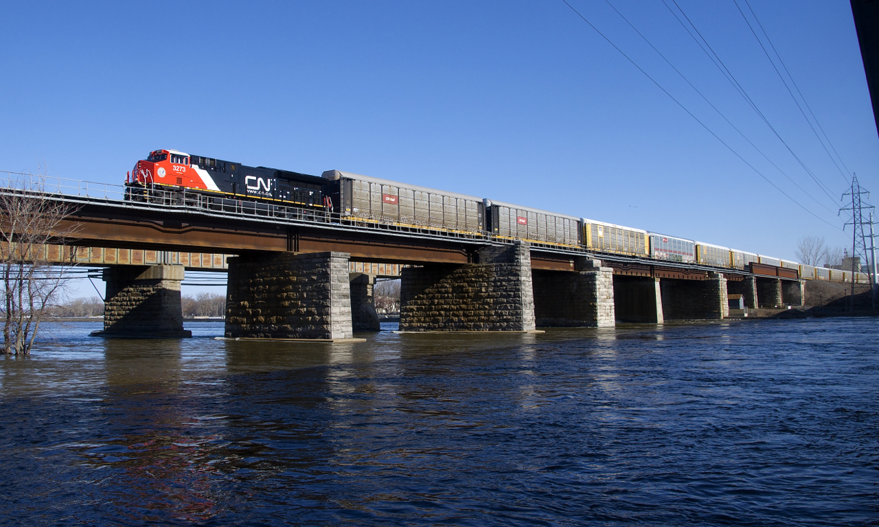Brand new ET44AC CN 3273 has 105 empty autoracks on the drawbar as it leaves the island of Montreal.