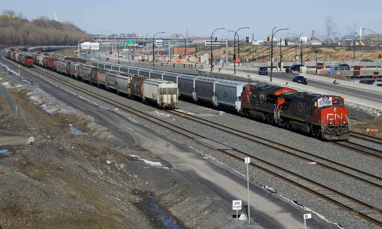 CN X309 with CN 2685 & CN 3145 for power has 171 grain empties (including some relatively new CN hoppers) as it approaches Turcot Ouest where it will change crews. At left two tracks of the Montreal Sub (track 29 and the freight track) have loaded grain cars stored on them.