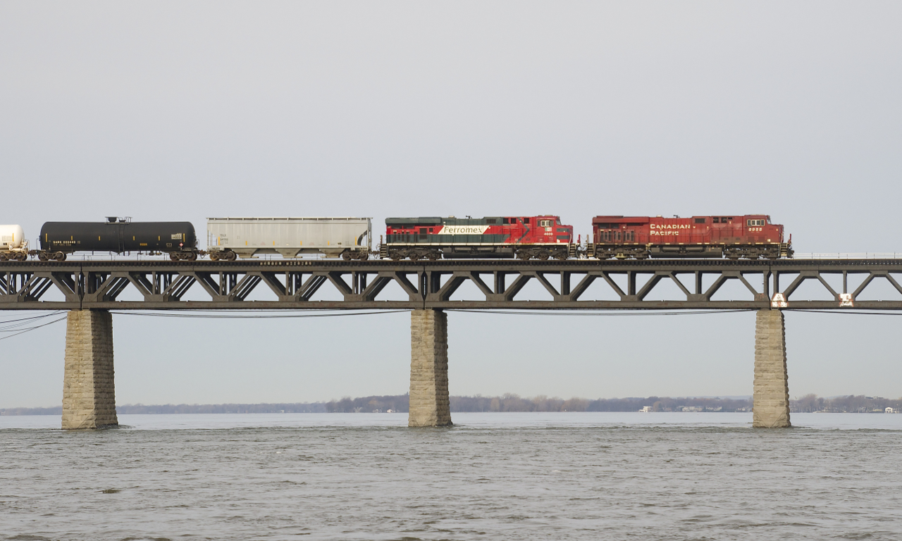 ES44AC's from a Canadian and a Mexican railway (CP 8955 & FXE 4609) are on a train that originated in the U.S. (CP 253) as they cross the St. Lawrence River.