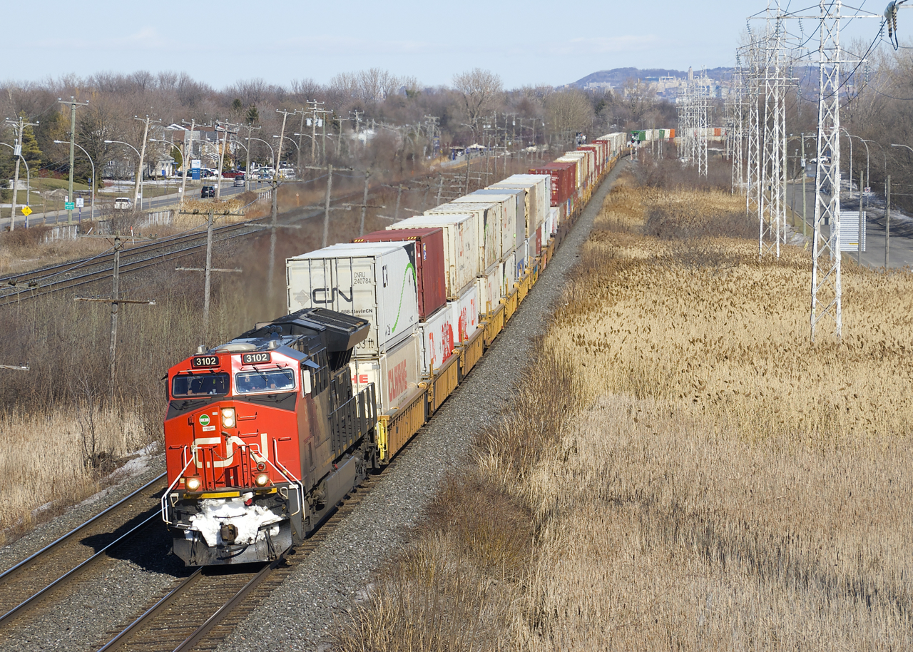 A very late and a very lengthy CN 121 (205 platforms) approaches MP 14 of CN's Kingston Sub with CN 3102 up front and CN 2966 mid-train on a windy afternoon.